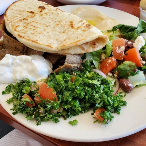 Gyro Platter - Tender, seasoned gyro meat served on a platter with rice, salad, pita bread, and our signature tzatziki sauce — a customer favorite.
